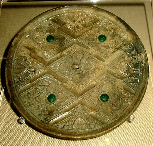 周後期または漢初期の中国の青銅鏡で、ガラスが象嵌されており、おそらくギリシャ・ローマの芸術的模様が組み込まれている。
