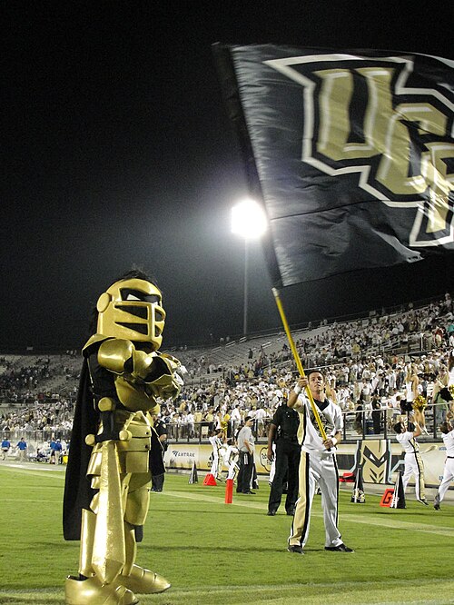 フットボールの試合中にフィールドに立つ、UCF の黒と金色のマスコット、ナイトロ。