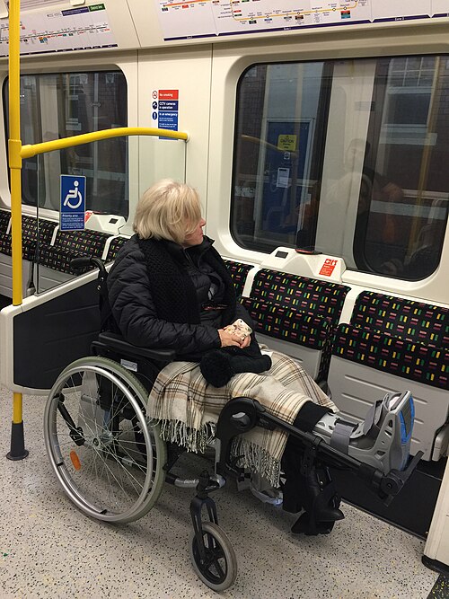 地下鉄の車内予約スペースに車椅子に乗った人が停まっている写真。