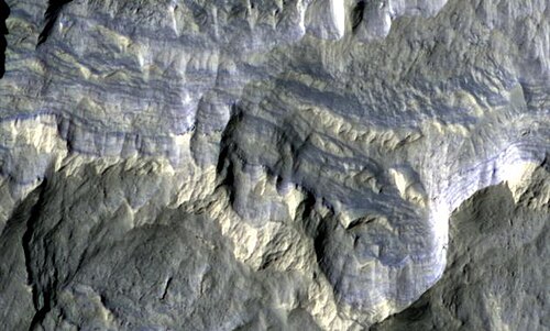 HiRISEが撮影したコロンバス・クレーターの地層。この擬似カラー画像は、直径約800フィート（約240メートル）です。地層の一部には、含水鉱物が含まれています。