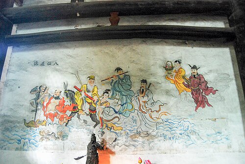 四川省にある、海を渡る八仙人を描いた壁画。右から2番目に描かれた藍才和は金色で、花籠を持っている。