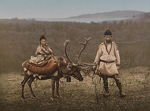 ノルウェー北部フィンマルク地方で1890年から1900年頃に撮影された、トナカイの横に立つサーミ人の男性と、そのトナカイの上に座る子供を写した歴史的な写真。