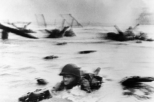 波打ち際を腹ばいになって這うアメリカ兵のぼやけた写真