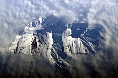 アバチンスキー山の山頂の火口と雪に覆われた斜面を強調した宇宙飛行士の写真。