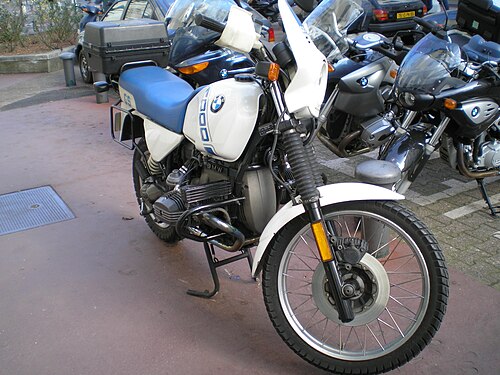白いBMW R100GSが他のバイクの前に駐車されている