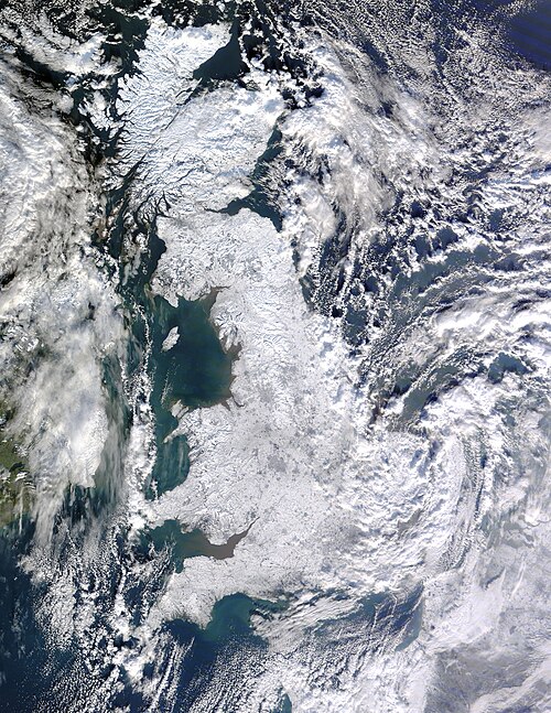 イギリスとアイルランドの衛星写真。イギリスは雪に覆われて白く、アイルランドは東部に雪が残っているものの大部分が緑です。雲は周囲の海とアイルランド東部、そしてイギリス東海岸(特に南東部)に散らばっています。