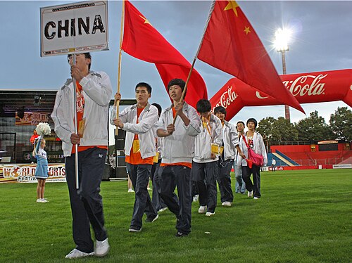 世界スポーツフェスティバルのスタジアムに中華人民共和国の国旗を持って入場する中国代表団。