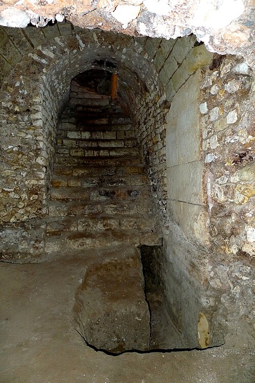 Vue d'un couloir voûté muni d'un escalier。 Légende détaillée ci-dessous。