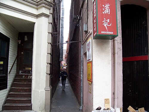 路地を歩く男性の写真
