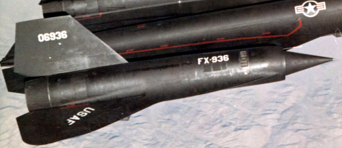 エンジンナセルが翼の途中まで出ている黒いデルタ翼の航空機の一部。胴体には米国空軍の記章、翼には「USAF」のラベル、ナセルには「FX-936」のコードが刻まれている。