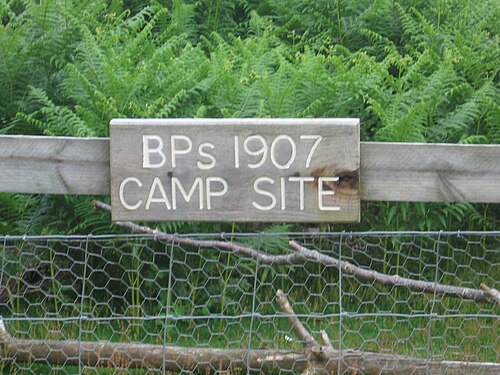 フェンスに掲げられた「BP の 1907 年キャンプ地」と書かれた木製の看板