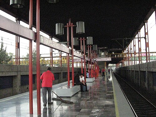 駅のホームでは多くの人が座って待っています。
