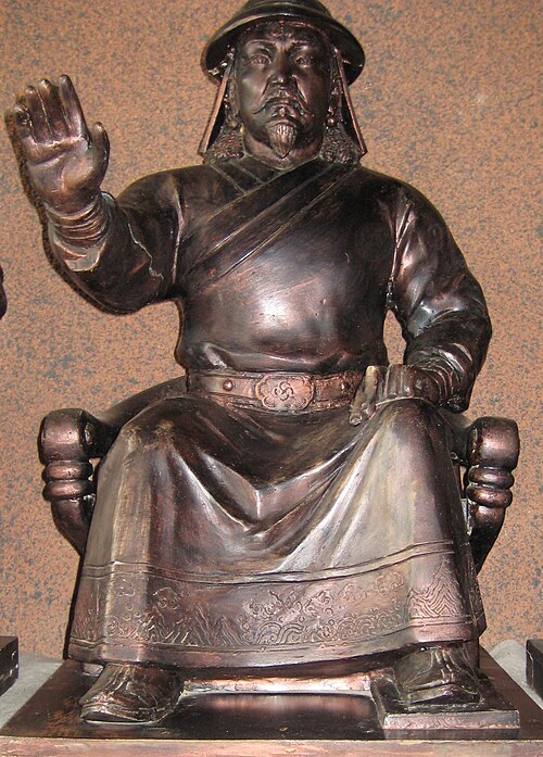 椅子に腕を伸ばして座っている男性の像
