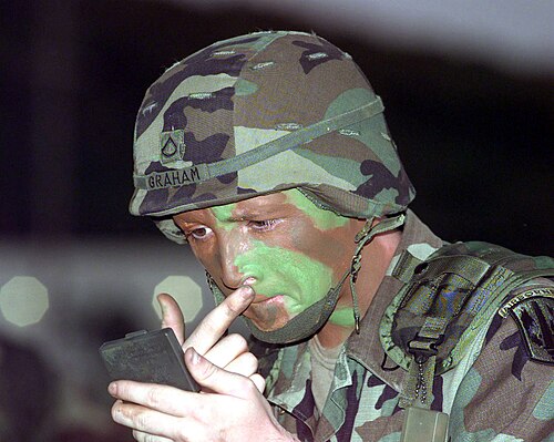 兵士が迷彩フェイスペイントを施している写真