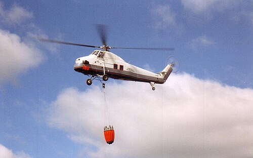 MNR 契約消防航空機の作業風景: バンビ水バケツを装備した S-58T、オンタリオ州ドライデン近郊、1995 年