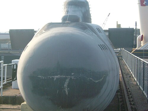 造船所に停泊中の小型潜水艦を正面から撮影した写真。