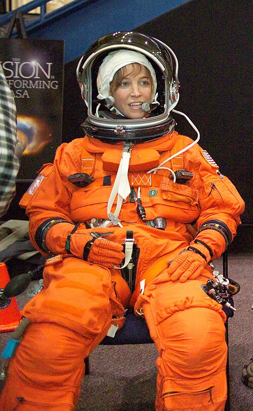 オレンジ色の宇宙服を着て微笑むノワックさん