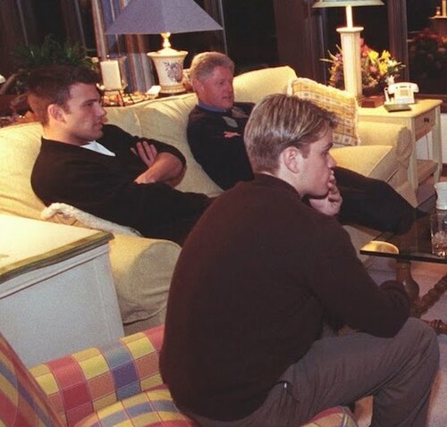 ビル・クリントン、ベン・アフレック、マット・デイモンが2つのソファに座り、テレビ画面を見つめている。