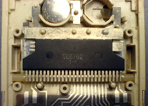 1980年代のシャープ製ポケット電卓に搭載されていたプロセッサチップ（集積回路パッケージ）には、SC6762 1•Hと刻印されている。チップの真下には液晶ディスプレイ（LCD）が配置されている。これはプリント基板（PCB）を使用しない設計で、ディスクリート部​​品は一切使用されていない。上部の電池収納部にはボタン電池を2個収納できる。