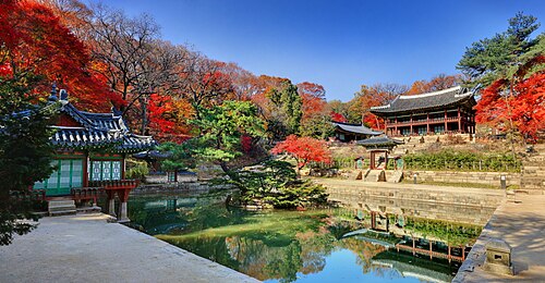 蓮の葉で覆われた池の上にある小さなカラフルな木造のパビリオン