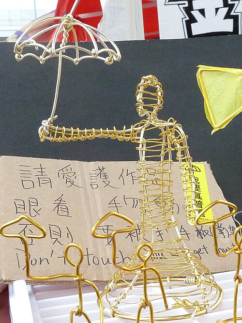 傘を持った男性のワイヤー像