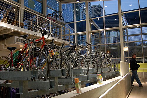 屋内の自転車ラックに駐輪された自転車の側面図。ラックの向こう側には高い窓がある。