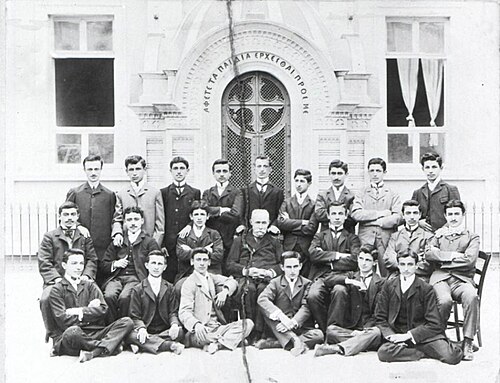 学校の前に3列に並んだポントス系ギリシャ人の男性と少年たち。彼らは西洋風のスーツを着ている。
