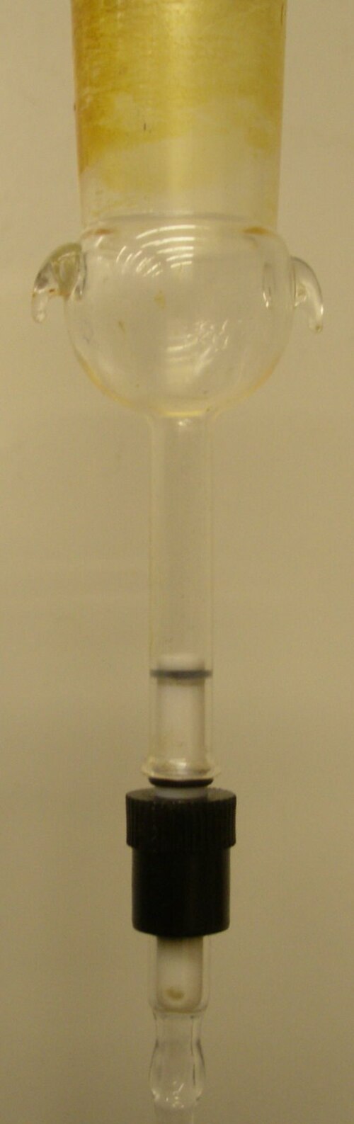 グリースが塗布されたメス 24/40 ジョイントを備えたアダプタに取り付けられた J. Young NMR チューブ。PTFE プラグの側面にある T ボアから生じた穴に注意してください。