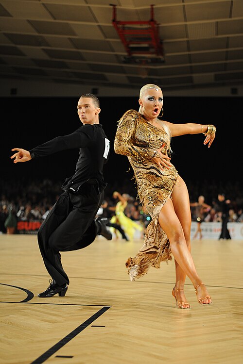 ラテンダンスのカップルがダンススポーツイベントでサンバのダンスを披露します。