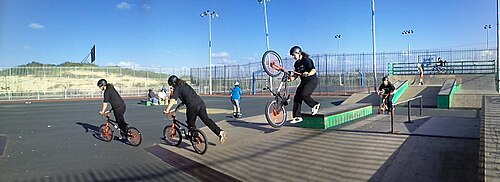 自転車競技場で自転車に乗る男性の複数の姿を合成した写真