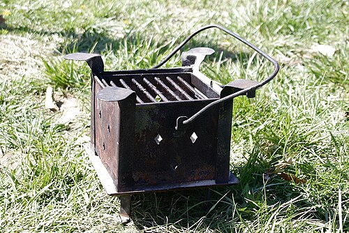 シンプルな箱型の火鉢で、幅広のグリルが付いています。金属製の容器（やかんやトレイなど）をヒーターや調理器具として使うことを想定しています。