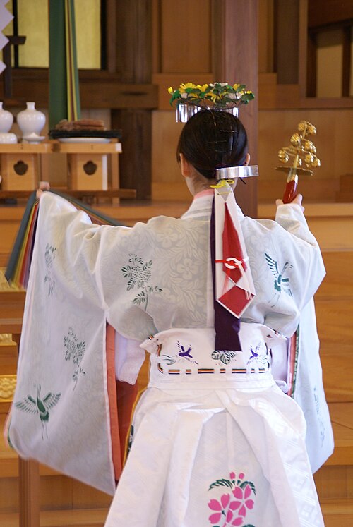 右手に鈴を持つ巫女