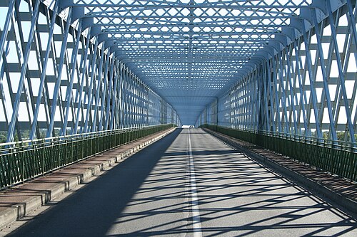 エッフェル塔を彷彿とさせるスタイルの、絡み合った鉄格子で囲まれた 2 車線の道路。
