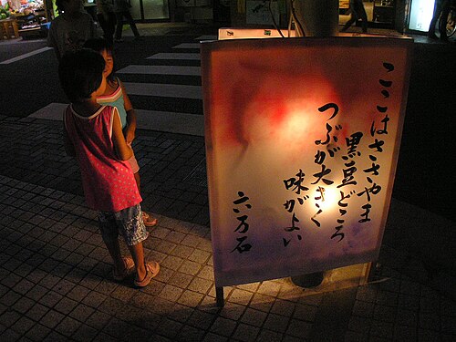 片側が開いた屋外に立つ行燈