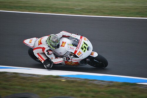白く塗られたレーシングバイクで右折中のライダー