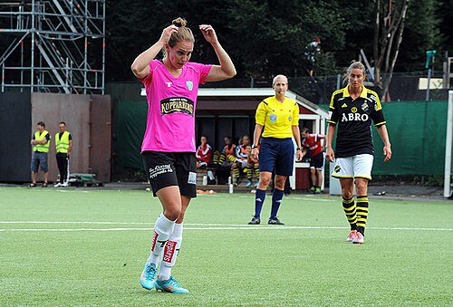 ピンクと黒のサッカーユニフォームを着た女性