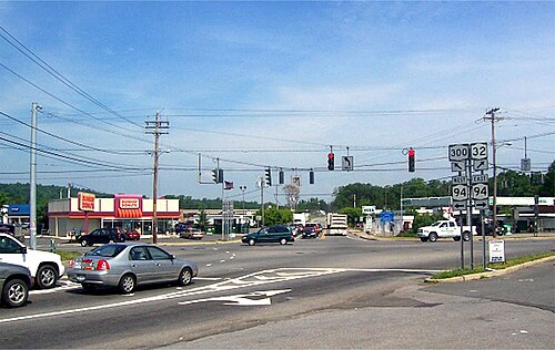 いくつかの商業施設からなるエリアにある、3 つの高速道路が交わる信号付きの五叉路交差点。
