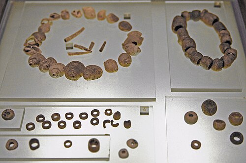 穴のあいた貝殻、石灰岩、バリサイト真珠。古墳 A、上層、4 千年紀。