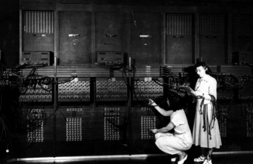 立っているマーリン・ウェスコフとルース・リヒターマンは、1946 年に ENIAC を再プログラムしました。
