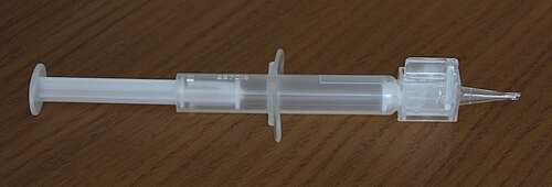 レンズ挿入ノズルが取り付けられた小型のプラスチック製使い捨て注射器。ノズルは先端が細くなっており、そこから折り畳み式レンズが後嚢に押し出され、幅 2.8 mm の切開部に適合します。