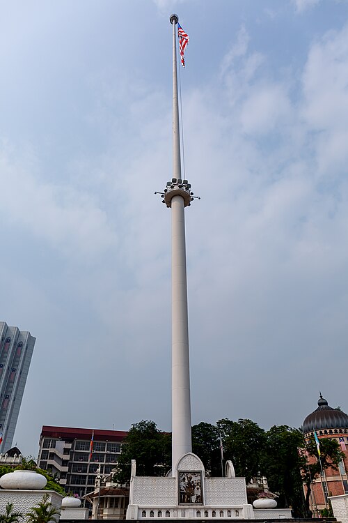マレーシアの国旗が掲げられた背の高い白い旗竿。