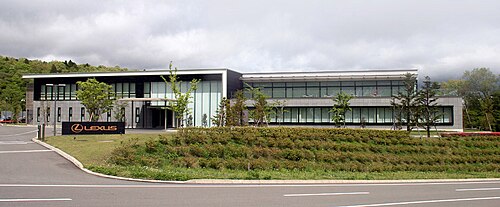 長方形の窓のある建物で、造園が施され、正面に「Lexus」と書かれた看板があります。