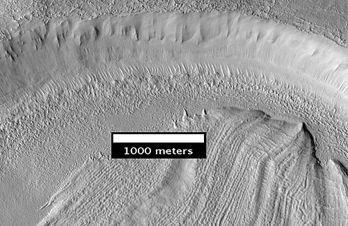 同心円状のクレーターの充填 HiRISE が撮影した、前の画像の上部付近のクローズアップ。表面の破片が水の氷を覆っています。