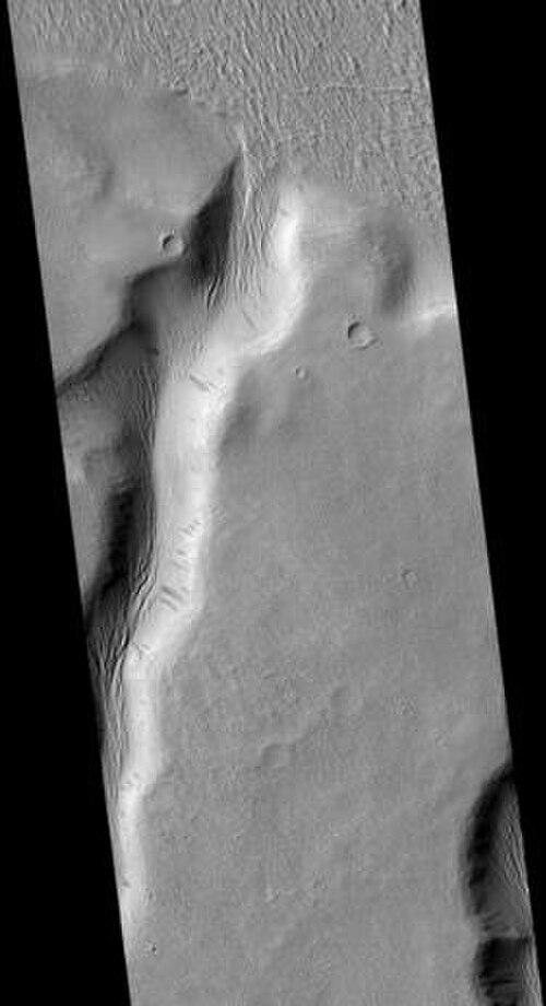 HiRISE が撮影したティニア・バレス。フルサイズの画像には斜面の暗い筋が写っています。