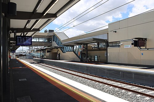 ボンビーチ駅の駅舎（低床式）と、その背景に写る1番線ホーム