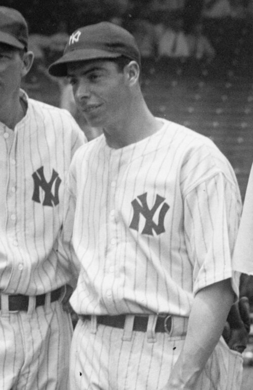 野球選手のジョー・ディマジオが「NY」の帽子とシャツを着ている姿を、中距離から捉えたショット。