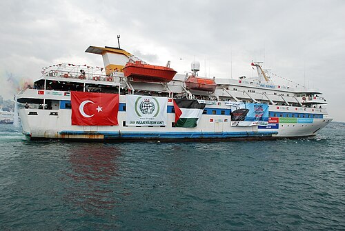 トルコとパレスチナの旗が飾られた白いクルーザーヨットの写真