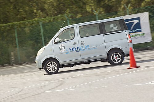 アルミホイールを装備した小型乗用バンが交通コーンの周りを高速で走行している