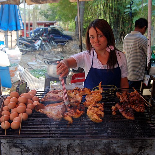 タイのチェンマイにあるフアイケーオ滝の入り口にある小さなレストランで、鶏肉、豚肉、卵が焼かれている。