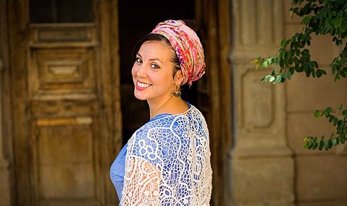髪の毛を「テファック」（許容される最大量）露出させるヘッドラップを着けた女性